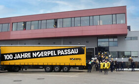 100 Jahre Noerpel Passau LKW Auflieger, Mitarbeiter vor Gebäude mit Luftballons