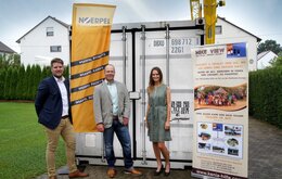 Drei Mitarbeiter vor Noerpel Flagge und Hilfe für Kenia Aufsteller