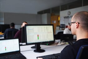 Mitarbeiter am Bildschirm mit Speditionssoftware